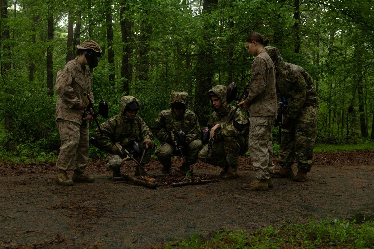 Veteran trainer demonstrating crisis recall training technique with unleashed dog near road